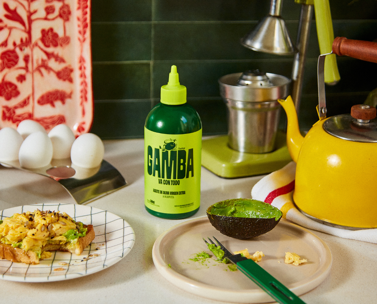 Botella squeeze de Gamba en la cocina, con una tostada de huevos revueltos y medio palta