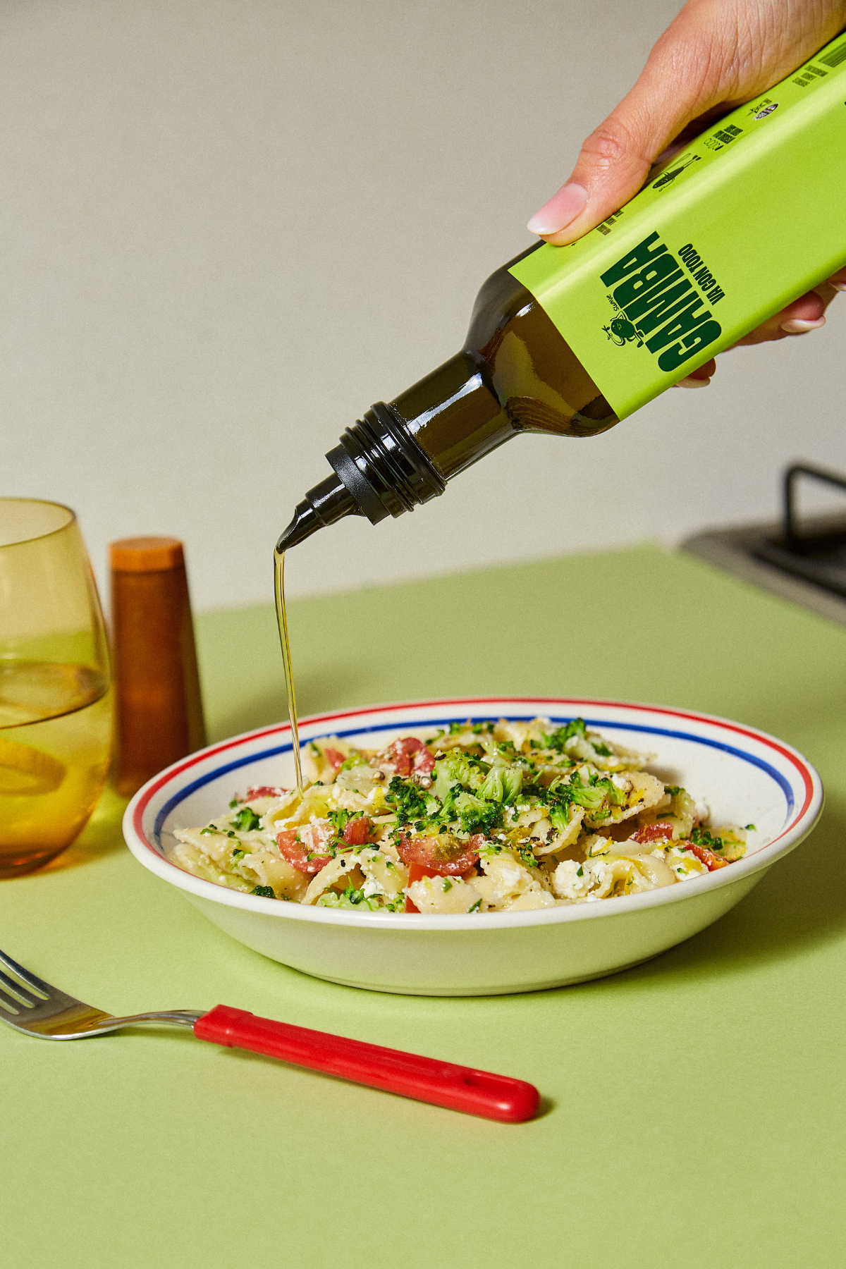 Chorro de Gamba desde la botella de vidrio sobre un bowl de pasta